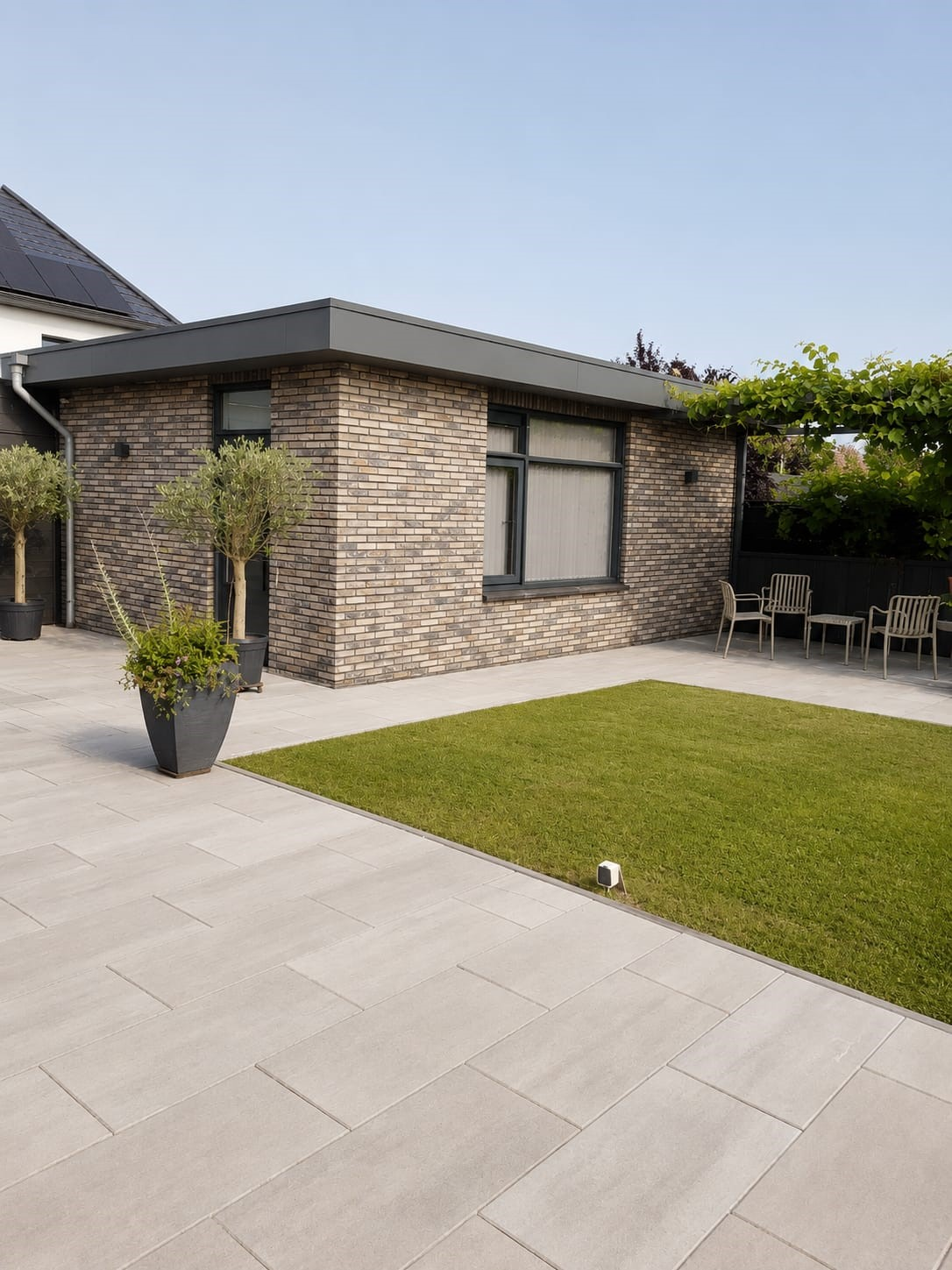 Het vrijstaande tuinhuis met terras en tuin